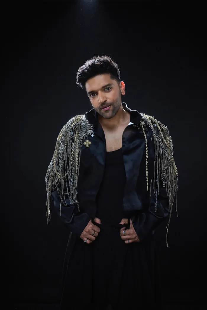 Guru Randhawa in a black jacket with chain fringe on the shoulders