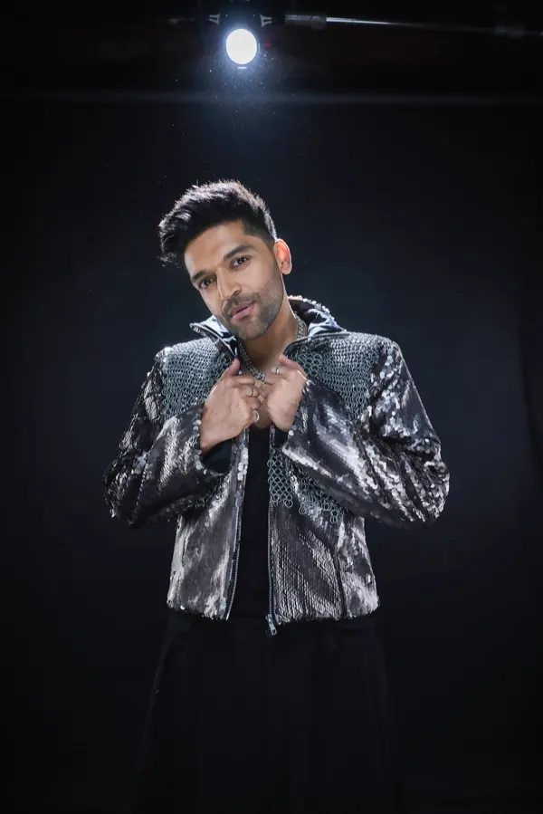 Guru Randhawa beneath a single stage light