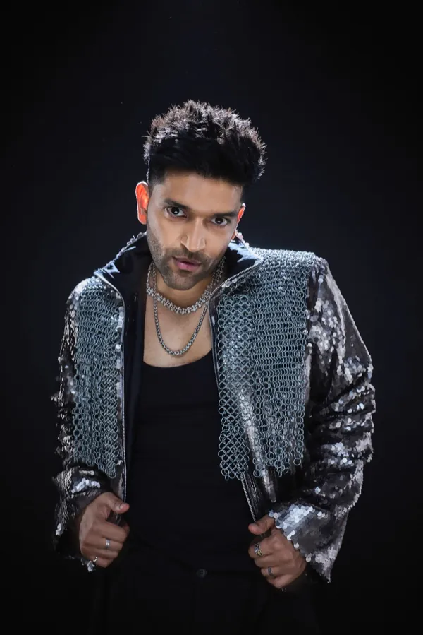 Guru Randhawa in an open sequin jacket, looking into the camera