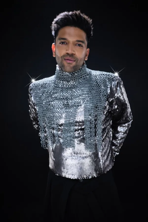 Guru Randhawa in a silver sequin jacket, looking into the camera