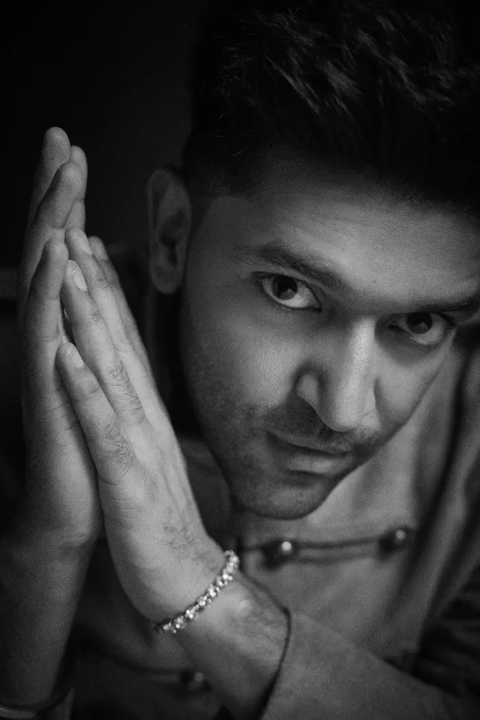 Black-and-white portrait of Guru Randhawa, hands pressed together